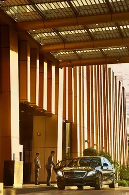 two men standing next to a car in a building at Hyatt Regency Manila City of Dreams in Manila
