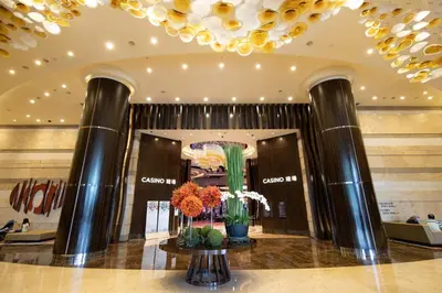 a lobby of a shopping mall with columns and flowers at Hyatt Regency Manila City of Dreams in Manila