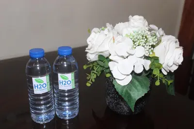 two bottles of water sitting next to a vase of flowers at Condo 1 Palm Tree Across NAIA T3 in Manila