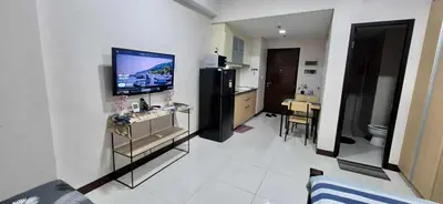 a living room with a flat screen tv on a wall at A&G Condotel at 101 Newport Across NAIA T3 in Manila