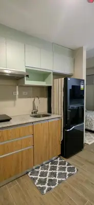 a kitchen with a sink and a black refrigerator at Le Palis Suite in Bukal