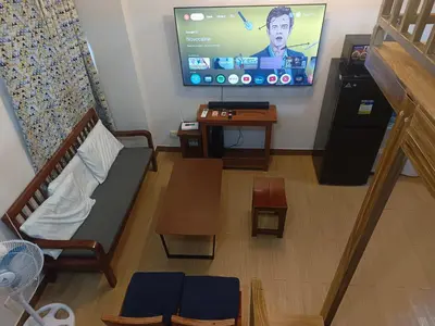 a living room with a couch and a flat screen tv at Happy Stays C - 300mbps - 65