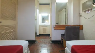 a room with two beds and a mirror at RedDoorz at Broadway Court Apartelle II Quezon City in Manila