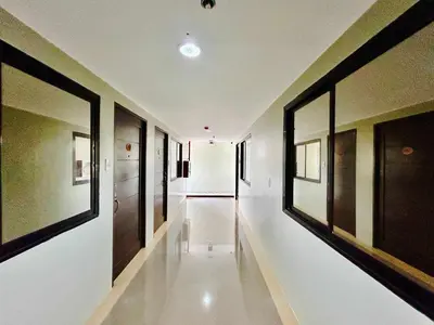 a hallway with white walls and black framed windows at OYO 1045 Rayjan Apartelle in Manila