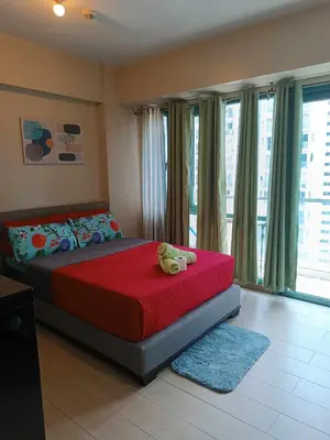 a bedroom with a bed with a teddy bear on it at RG condotel Near Naia Terminal 3 in Manila