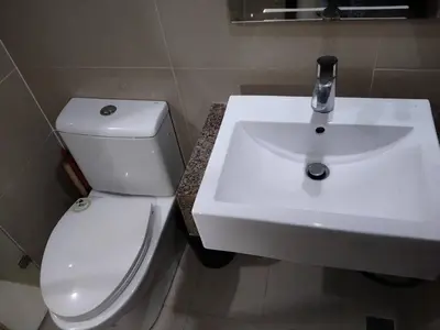a bathroom with a white sink and a toilet at RG condotel Near Naia Terminal 3 in Manila