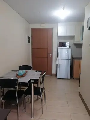 a kitchen with a table and chairs and a refrigerator at RG condotel Near Naia Terminal 3 in Manila
