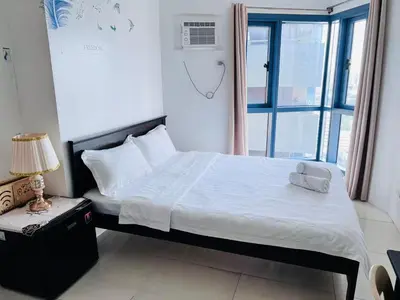 a bedroom with a large bed with a window at Dreamy Sunset Bay in Manila
