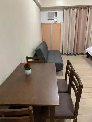 a room with a table and chairs and a couch at RAMCONDOTEL in Manila