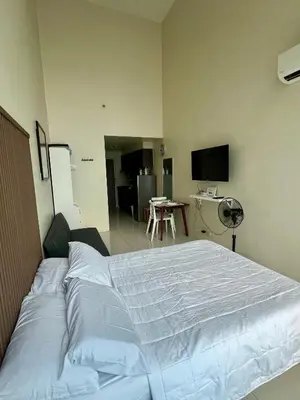 a bedroom with a large bed in a room at Cozy High Ceiling Studio @ Ortigas near Podium, Megamall in Manila