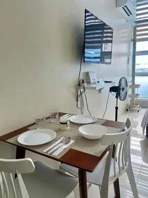 a dining room table with two plates and two chairs at Cozy High Ceiling Studio @ Ortigas near Podium, Megamall in Manila