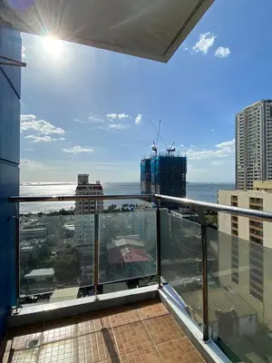 a balcony of a building with a view of the ocean at Malate Bayview Mansion 17A/B in Manila