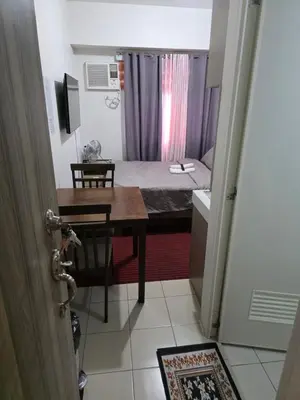 a small room with a bed and a table and a desk at Pierrecondotel in Manila