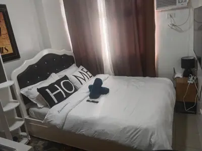a bed with a blue teddy bear on top of it at Pierrecondotel in Manila