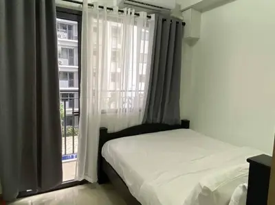 a bedroom with a bed and a large window at Shore Residence D21 shortwalk MOA Balconypoolview in Manila