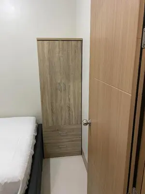 a bedroom with a wooden door and a bed at Ella’s Condo@Shore3 T3 in Manila