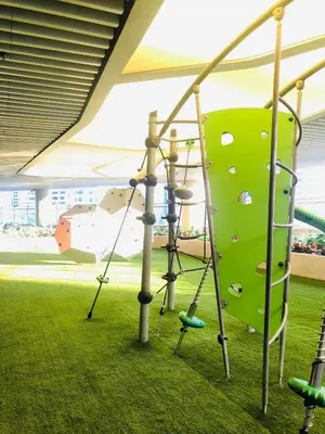 a climbing gym with a green rock wall at Urbanview Oasis at Air Residences in Manila