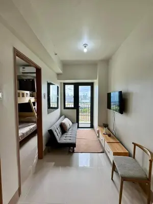 a living room with a couch and a television at SHORE 3 RESIDENCES TOWER 2 in Manila