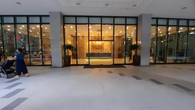 a woman pushing a stroller in front of a building at Bonifacio global city one uptown residence-2 Bedroom in Manila