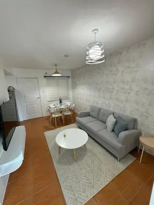 a living room with a couch and a table at Modern Oasis: Pool + Netflix in Manila