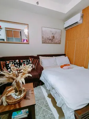a bedroom with a bed and a couch and a table at CAMP CJ Staycation A Cozy, Modern Studio near BGC & MRT Boni, Perfect for Relaxing City Getaways in Manila