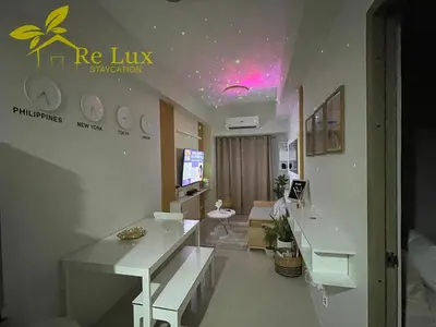 a room with a white desk and a tv on the wall at Re Lux Staycation, NEAR NAIA in Manila