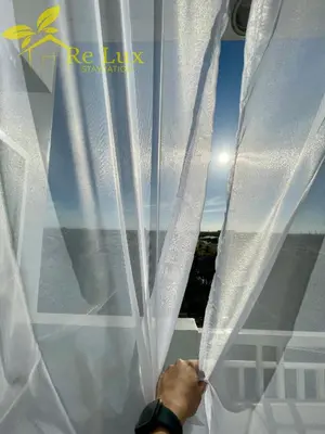 a person is opening a white window curtain at Re Lux Staycation, NEAR NAIA in Manila