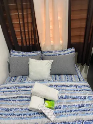 a bed with blue and white sheets and pillows at Pierrecondotel in Manila