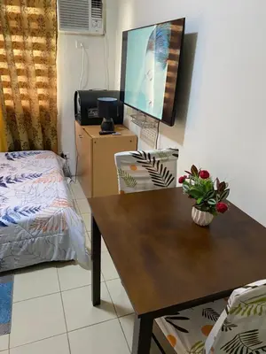 a room with a desk with a tv and a bed at Pierrecondotel in Manila