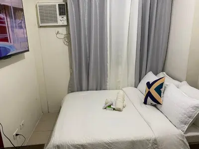 a small bedroom with a bed and a window at Pierrecondotel in Manila