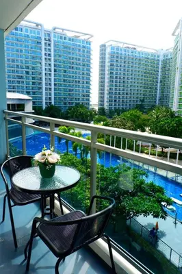 a balcony with a table and chairs and a pool at Azure Urban Resort Residences Paranaque 2 Bedroom Unit in Manila