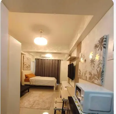 a small room with a bed and a tv at Condotel-Shore 2 Residences MOA in Manila