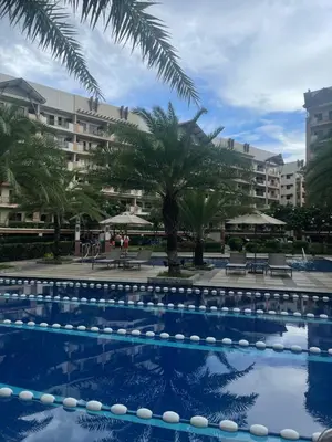 a pool at the resort with palm trees and buildings at Family Suite w/ Centralized AC nr Ayala Mall Feliz in Manila