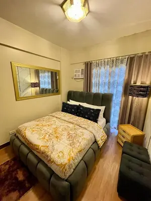 a bedroom with a large bed and a couch at Family Suite w/ Centralized AC nr Ayala Mall Feliz in Manila