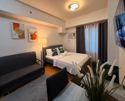a small room with a bed and a couch at Modern Condo near St Lukes and US Embassy in Ermita Manila in Manila