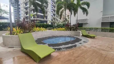 a patio with chairs and a pool in a building at 11C Tower 1 Viceroy Residences McKinley BGC in Manila