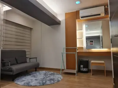 a living room with a couch and a mirror at Cozy 2BR in BGC near golf course - B Fort TB in Manila