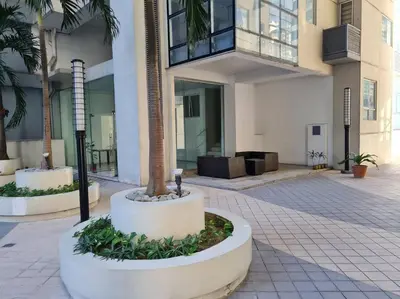 a building with a palm tree in a courtyard at Cozy 2BR in BGC near golf course - B Fort TB in Manila