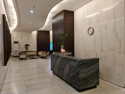 a lobby with a clock on the wall and tables at Cozy 2BR in BGC near golf course - B Fort TB in Manila