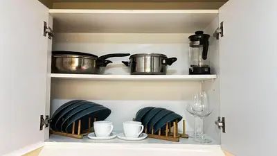 a cupboard filled with pots and pans and plates at Uptown Parksuites Tower Two - BGC Taguig, Manila in Manila