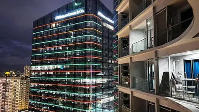 a tall building with lights on the side of it at Uptown Parksuites Tower Two - BGC Taguig, Manila in Manila