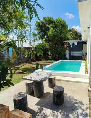 a table and stools next to a swimming pool at Matthew's Private Pool by Mia and Miguel's House in General Trias