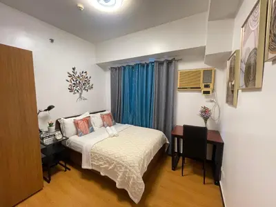 a hotel room with a bed and a desk and a bed sidx sidx sidx sidx at 1 Bedroom Homestay in 8 Adriatico Manila in Manila