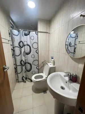 a bathroom with a toilet and a sink and a mirror at 1 Bedroom Homestay in 8 Adriatico Manila in Manila