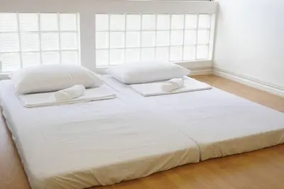 a large white bed with two pillows on it at Makati Altean Apartment (Maura Room) in Manila