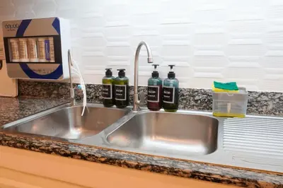 a kitchen sink with three bottles of wine at Makati Altean Apartment (Maura Room) in Manila
