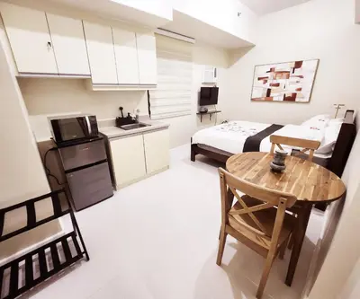 a kitchen and a bedroom with a table and a bed at KL Tower Condo, Makati City in Manila