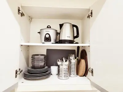 a cupboard with a coffee maker and dishes in it at KL Tower Condo, Makati City in Manila