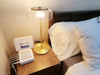 a lamp on a table next to a bed at KL Tower Condo, Makati City in Manila