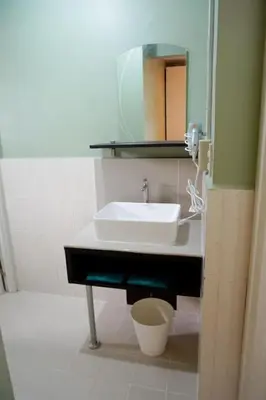 a bathroom with a sink and a mirror at ALTEAN Apartments - Lourdes Room in Manila